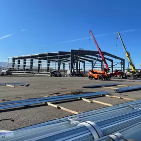 The image shows a construction site where a large steel structure is being erected. Steel Concepts ensures that every project is built to last, providing safety, comfort, and peace of mind.