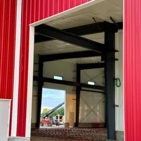 We're Building America recently completed a multi-use industrial steel frame building with an industry partner in Thornton, ID. The project showcases a partially built structure with red exterior walls and visible steel framework