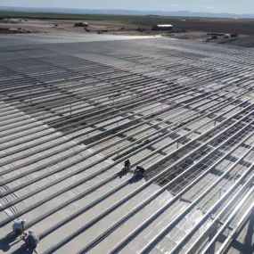 Steel Concepts Inc. specializes in precision-engineered steel structures for large-scale agricultural and industrial projects. This image captures expert installation of a durable metal roofing system, designed for longevity and weather resistance. Our commitment to quality ensures efficiency and strength in every build.