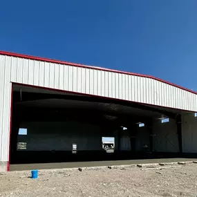 Steel aviation hangar under construction by Steel Concepts in St. Anthony, ID, showing white siding, red trim, and open structure during steel building erection.

Description:
Steel Concepts performing steel building erection for a 6,400 sq ft industrial aviation hangar project in St. Anthony, ID. Image showcases the building's structure during construction.