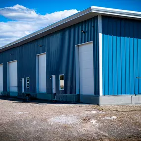 An 8,000 SQFT steel fabrication machine shop constructed by Steel Concepts, Inc. for UpFab LLC in St. Anthony, ID. This modern facility, characterized by its blue metal siding and multiple white overhead doors, was custom-designed for efficiency, precision, and long-term growth, supporting high-capacity operations with robust structural integrity and advanced steel framing for specialized machinery.