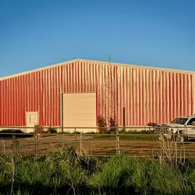 A recently completed 10,800 SQFT riding arena in Idaho Falls by Steel Concepts, Inc. Designed for durability and year-round use, this facility features a robust steel frame and provides a safe, functional space for equestrian activities. The image shows a large steel building, representative of Steel Concepts' construction expertise in creating high-performance agricultural and recreational facilities.