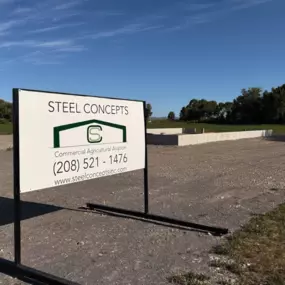 The sky is clear and blue, with trees lining the horizon. This image effectively represents Steel Concepts' involvement in commercial agricultural aviation construction projects.