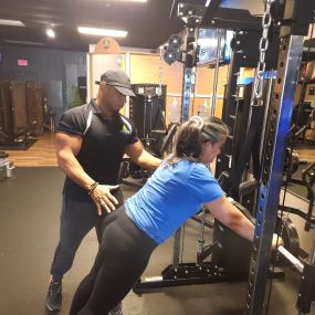 Dennis personal training his client and coach her on push ups.