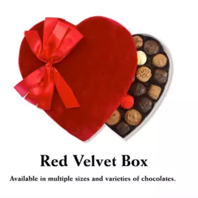 A Valentine's Day-themed Red Velvet Box featuring Florence’s Exquisite Chocolates in Rexburg, ID. This heart-shaped chocolate box is covered in plush red velvet fabric and adorned with a luxurious satin bow. Inside, an assortment of handcrafted chocolates, including milk, dark, and white varieties, are neatly arranged, showcasing their intricate designs and textures. The elegant presentation makes it an ideal romantic gift. The text below highlights that the Red Velvet Box is available in multip