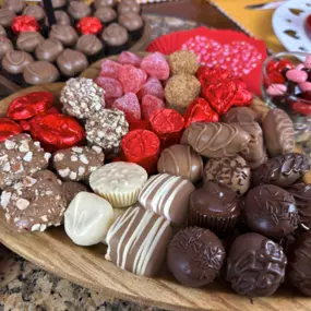 An artfully arranged platter featuring Florence's exquisite chocolates and confections. Located in Rexburg, Idaho, Florence’s Chocolates offers a premium selection of handcrafted sweets, including decadent truffles, chocolate-dipped delights, and heart-shaped treats. Perfect for gifting or indulging during special