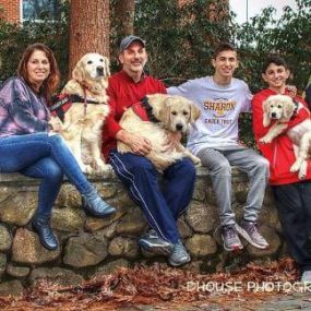 Beth and Steve Weiss with their family, including the golden retriever trainees.