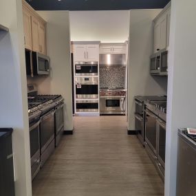 Hallway with kitchen ranges and wall ovens on display