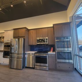 Kitchen showroom with wooden cabinets and stainless steel appliances