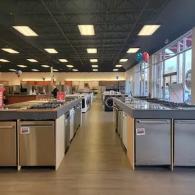 Appliance showroom with dishwashers and stove tops on display