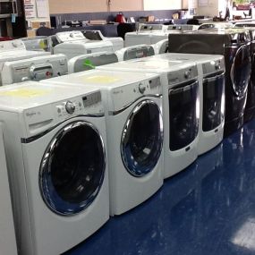 White washing machines on display with blue flooring