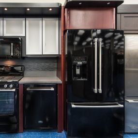 kitchen appliance display with two refrigerators, a dishwasher, a range, and a microwave