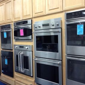 Multiple built in wall ovens on display with wooden cabinetry
