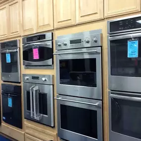 Multiple built in wall ovens on display with wooden cabinetry