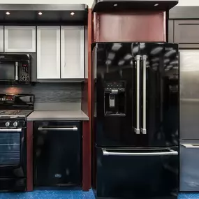 kitchen appliance display with two refrigerators, a dishwasher, a range, and a microwave