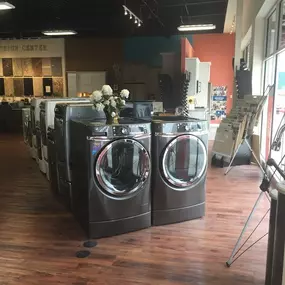 Appliance showroom with wooden flooring and laundry appliances on display