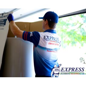 Express Plumbing Heating & Air technician unboxing a new water heater for a customer.