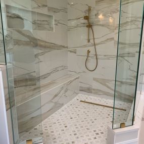 Remodeled shower using frameless glass, gold fixtures ,slab walls and linear drain!
