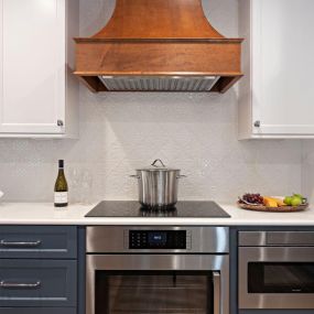 A stunning Palm Beach Gardens kitchen renovation with a Showplace Cabinetry Range Hood and Pompeii Quartz countertops in Misterio.