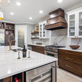 Kitchen remodel featuring gorgeous wood hood, cambria countertops and full backsplash.