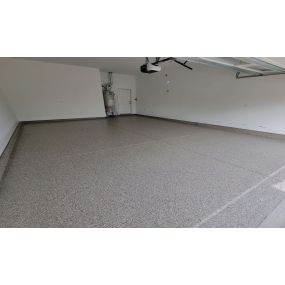 Commercial grade epoxy floors provide a clean updated appearance to worn garage floor concrete.
