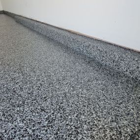 Upgrade your garage with cutting-edge polyspartic flooring, Graphite color shown! Say goodbye to stains and hello to unmatched durability and style.