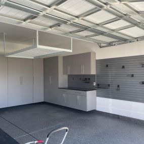 Garage makeover! Cabinets, overhead storage, slat wall w accessory hooks and durable epoxy floors.