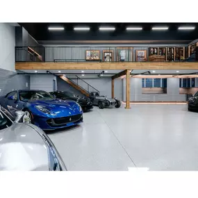 Our team of experts is here to help you choose the perfect storage options for your garage as seen in this upper garage loft & we specialize in beautiful commercial grade epoxy floors.