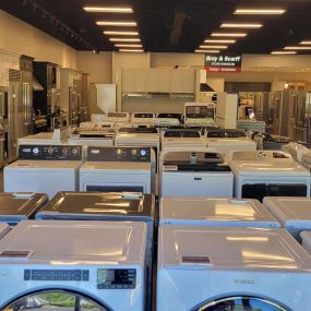 Appliance showroom with multiple white washing machines on display