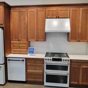 kitchen showroom with appliances on display and wooden cabinetry