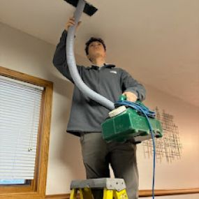 A team member at Scrubber Duct Cleaning an air vent