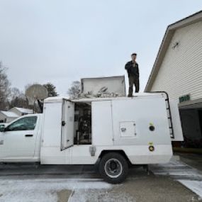 A Scrubber Duct team member standing on top of their equipment truck.