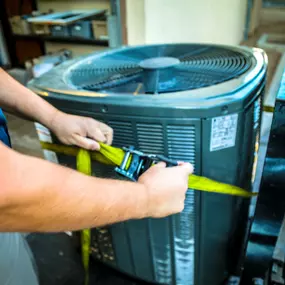 HVAC equipment being strapped to a forklift