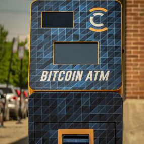 A CoinFlip Bitcoin ATM with display screen, QR camera reader and cash intake slot.