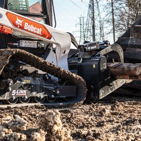 Bobcat industrial grapple attachment lifts large chunks of concrete.