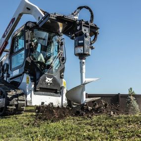 Bobcat S590 skid-steer loader uses planetary auger attachment to dig fence posts.