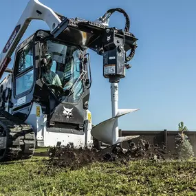 Bobcat S590 skid-steer loader uses planetary auger attachment to dig fence posts.