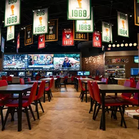 Photo of the spacious and beautifully furnished restaurant inside the Sportsbook at Plainridge Park Casino in Plainville, Massachusetts. There are rows of plush leather seats and polished wood tables that can accommodate large groups.