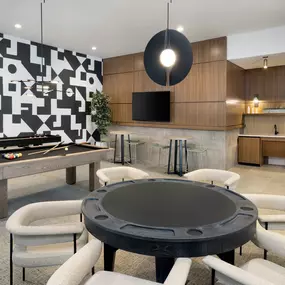 Resident game room with shuffleboard and game table at Camden Atlantic apartments in Plantation, Florida.