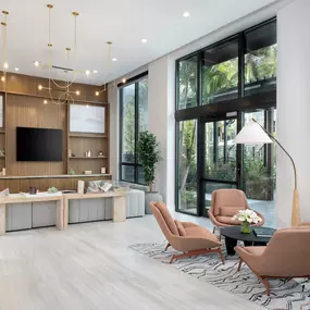 Resident lounge with seating areas and television at Camden Atlantic apartments in Plantation, Florida.