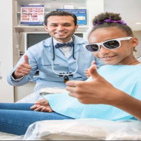 Dr. Patel thumbs up with young patient