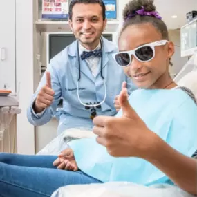 Dr. Patel thumbs up with young patient