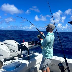 Man reeling in big fish on private boat charter Fishing Trip in Hawaii