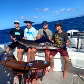 Group of friends holding Blue Marlin on the best fishing trip in Oahu, HI