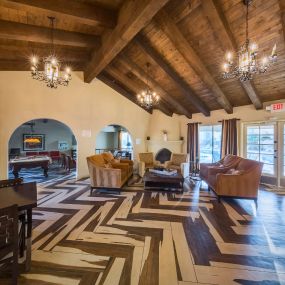 Resident Lounge with Herringbone Flooring,  Exposed Beams on the Ceiling, and Ample Cozy Seating