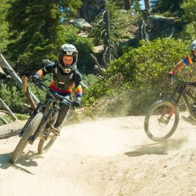 A kiddo and adult mountain bike riders ripping through the bike park at Snow Valley.