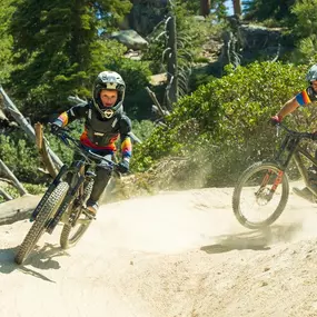 A kiddo and adult mountain bike riders ripping through the bike park at Snow Valley.