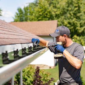 Tech installing GUtter GUard - Gutter Shutter