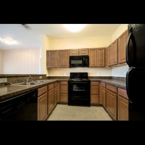 Kitchen with wooden cabinetry and black appliances