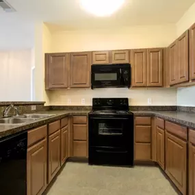 Kitchen with wooden cabinetry and black appliances